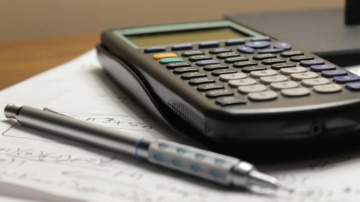 Graphing calculator and mechanical pencil on a sheet of handwritten maths notes